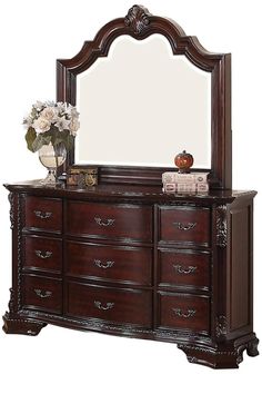 a dresser with a mirror and flowers on it