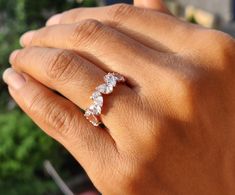 a woman's hand holding a ring with three stones on the middle of it