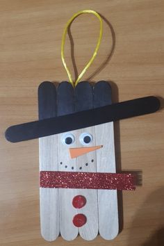 a popsicle snowman ornament made out of wood sticks