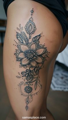 a woman's thigh with a flower tattoo on the side and an intricate design