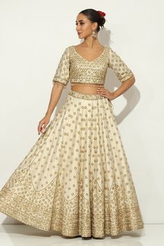 Ivory and gold kalidar lehenga with all over Padma bagh motif embroidery using zardozi highlights and tassel ornamentation. Paired with an elbow sleeves floral jaal embroidered leaf neck blouse with dangling glass beads hem and a bloom border embroidered dupatta. - Aza Fashions Raw Silk Embroidery, Embroidery Zardozi, Embroidered Leaf, Motif Embroidery, Embroidered Leaves, Embroidered Dupatta, Silk Embroidery, Elbow Sleeve, Bridal Lehenga