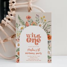 a birthday party card sitting on top of a table next to a wooden chair and plant