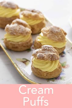 cream puffs with powdered sugar on top are sitting on a floral plate and next to a pink napkin