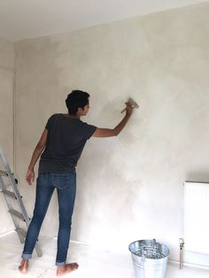 a man is painting the walls in an empty room