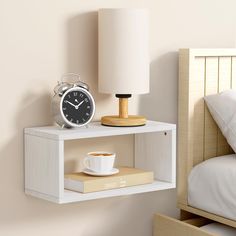 an alarm clock on a shelf next to a coffee cup and book in a bedroom