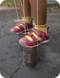 a person wearing pink shoes and yellow socks standing on top of a tin can pole