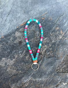 a blue, pink and green lanyard on a rock