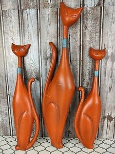 three orange ceramic cats sitting next to each other