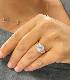 a woman's hand with a diamond ring on her left hand and the word ef written in gold