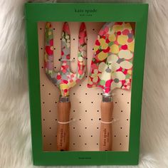 two colorful utensils are in a green box