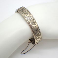 "Birks vintage wide hinged sterling silver cuff bracelet, decorated with gilt finish and engraved scroll patterns on the front side. It has box type closure with a safety chain. Made in England. This glorious bracelet is 6 1/2\" long on the inside, 1/2\" wide, weighing 19.4 grams. It features a couple of small dents. EA4659" Luxury Vintage Engraved Cuff Bracelet, Elegant Stamped Cuff Bracelet, Antique Cuff Bracelet With Intricate Design For Formal Occasions, Victorian Etched Cuff Bracelet, Victorian Etched Cuff Bracelet For Wedding, Ornate Stamped Bracelets For Formal Occasions, Victorian Sterling Silver Bracelet, Engraved For Formal Occasions, Antique Engraved Sterling Silver Bracelet For Formal Events, Victorian Sterling Silver Engraved Wedding Bracelet