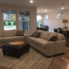 a living room with two couches and a coffee table in front of a window