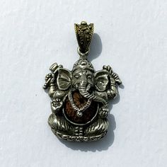 "This pendant is made with a Ganesh design with rudraksha seeds inserted in its stomach,  Ganesh is famous for intelligence and wisdom, while the rudraksha seeds come from the tears of Rudra or Lord Shiva which is believed to be full of the blessings of Lord Shiva, so it can bring health, peace, glory. Thus, this pendant is made to bless wisdom and peace. This pendant is handmade by Balinese silversmiths who have been in the field for many years. so you can make this pendant as a unique and magn Handmade Brown Necklace For Puja, Brown Necklaces For Puja And Festivals, Spiritual Festive Gift Jewelry, Festival Brown Necklace For Puja, Spiritual Necklaces For Navratri Gift, Spiritual Oxidized Necklaces For Puja, Silver Mala As Festival Gift, Silver Mala For Festival Gifts, Handmade Mala For Navratri Gift