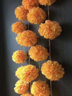 some yellow paper flowers hanging on a wall