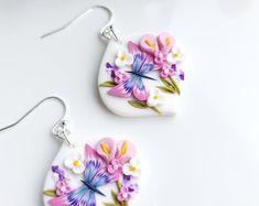 two white and pink earrings with flowers on them