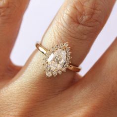 a woman's hand with a diamond ring on top of her finger and an engagement band