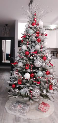 a white christmas tree with red and silver ornaments