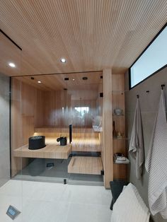 the inside of a bathroom with wooden walls and flooring, including an open shower