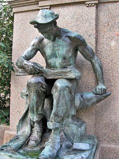 a statue of a man sitting on top of a bench