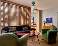 a living room filled with furniture and a wooden screen on the wall behind it's headboard