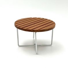 a small wooden table sitting on top of a white floor next to a metal frame