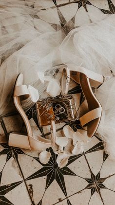 wedding shoes and veil on the floor in front of a star - patterned tile floor