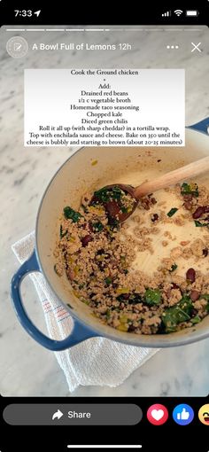 a pan filled with food sitting on top of a counter next to a wooden spoon