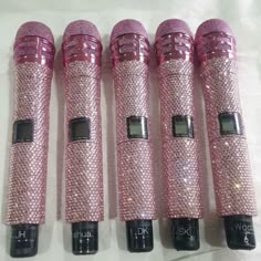 four pink microphones sitting next to each other