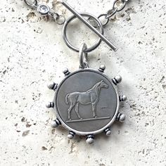 Expertly crafted and designed for longevity, the Cora Silver Horse Coin Necklace is the perfect accessory for any equine enthusiast. The handcrafted, non-tarnishing stainless steel chain ensures durability for years to come. Complete your look with this unique and elegant piece. Cora Silver Horse Coin Necklace Coin Pendant Approximate Size 30mm MADE IN USA Luxury Silver Horse Design Necklace, Horse Coin Necklace, Pearl Cluster Necklace, French Coins, Silver Horse, Toggle Necklace, Bee Pendant, Chunky Bracelets, Pearl Cluster