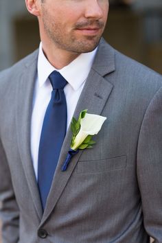 a man in a suit and tie with a boutonniere on his lapel