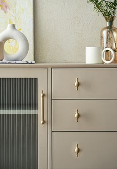 a white vase sitting on top of a wooden dresser