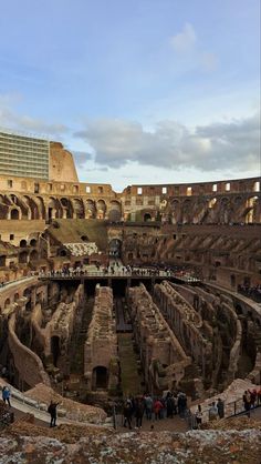 the interior of an ancient roman amphite with people standing around it and looking at the floor