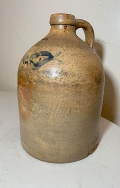 a brown vase sitting on top of a white table