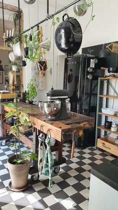 a kitchen filled with lots of pots and pans on top of a wooden table