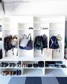 an organized closet with shoes, bags and handbags hanging on the wall next to it