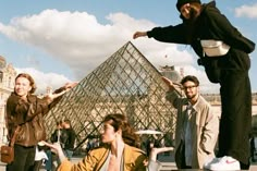 a group of people standing in front of a pyramid