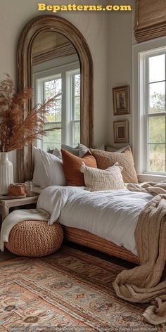 a bed with pillows and blankets in front of a large mirror on top of a wall