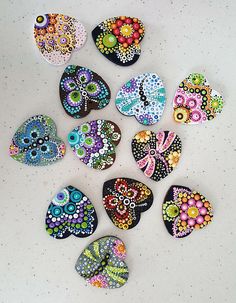 several colorful painted rocks sitting on top of a white table next to eachother