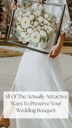 a woman in white dress holding up a frame with flowers on it and the words, all of the actually attractive ways to preserve your wedding bouquet