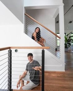 a man and woman are sitting on the stairs in their new home, looking at each other