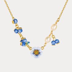 Blooming with summer sweetness, the Blueberry Flower Necklace is a captivating piece crafted in 18K gold plated brass. Each delicate petal is brought to life with vibrant enamel, capturing the essence of a blueberry blossom in its charming, rich blue hue. Made with meticulous attention to detail, the 18K gold plating and high-quality enamel ensure this necklace is a piece you'll treasure for years to come. Looking for the perfect gift for a nature lover or someone who appreciates unique and beau Gold Enamel Flower Jewelry, Blue Necklace With Flower Charm, Yellow Gold Enamel Flower Jewelry, Yellow Gold Enamel Jewelry With Flower Charm, Dainty Flower-shaped Enamel Jewelry, Yellow Gold Enamel Flower Pendant Jewelry, Blue Flower-shaped Jewelry With Beaded Chain, Spring Flower-shaped Jewelry With Adjustable Chain, Gold Flower-shaped Enamel Jewelry