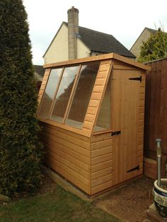 a small wooden shed sitting in the middle of a yard