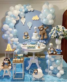 a blue and white baby shower party with balloons, teddy bears, cake and cupcakes