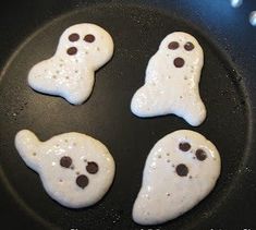 four ghost cookies cooking in a skillet