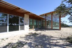 an empty building with large windows on the front and side of it in the desert