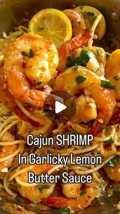 a bowl filled with pasta and shrimp next to lemon wedges on top of it