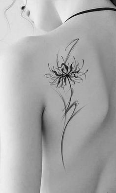 the back of a woman's shoulder with a flower tattoo on it