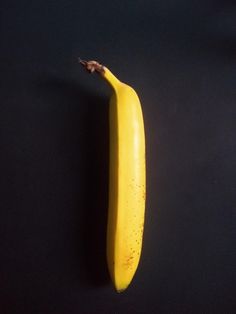 a yellow banana sitting on top of a black table