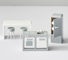 a toy kitchen set with stools, table and sink in white color on plain background