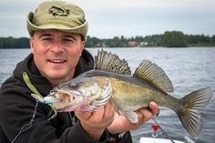 a man holding a large fish on a boat